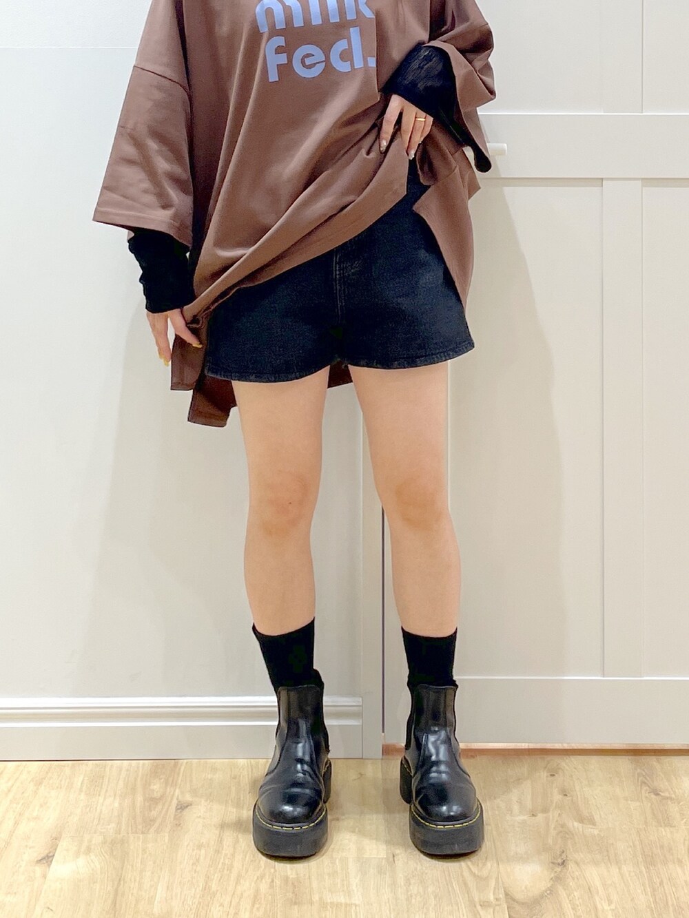 ブラウン系のTシャツ/カットソー、ブラック系のトートバッグ、ブラック系のブーツを着用したレディースの夏コーディネートの5枚目の写真