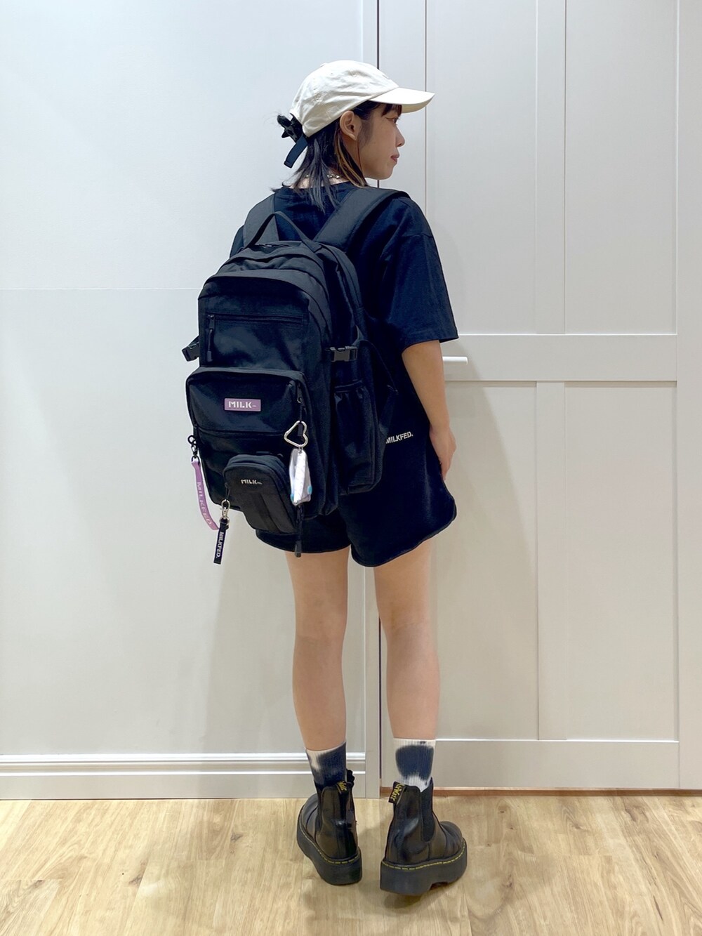 パープル系のバックパック/リュック、ブラック系のショルダーバッグ、ブラック系のブーツを着用したレディースの夏コーディネートの2枚目の写真