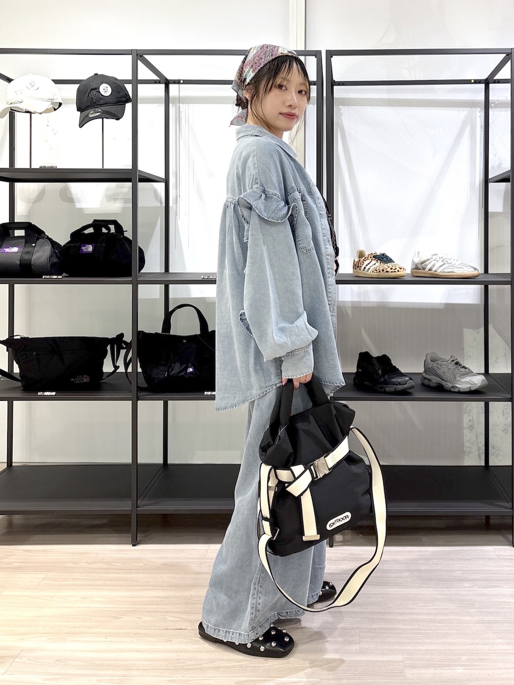 ブラック系のその他シューズ、ブラック系のトートバッグ、ブルー系のデニムパンツを着用したレディースの春コーディネートの3枚目の写真