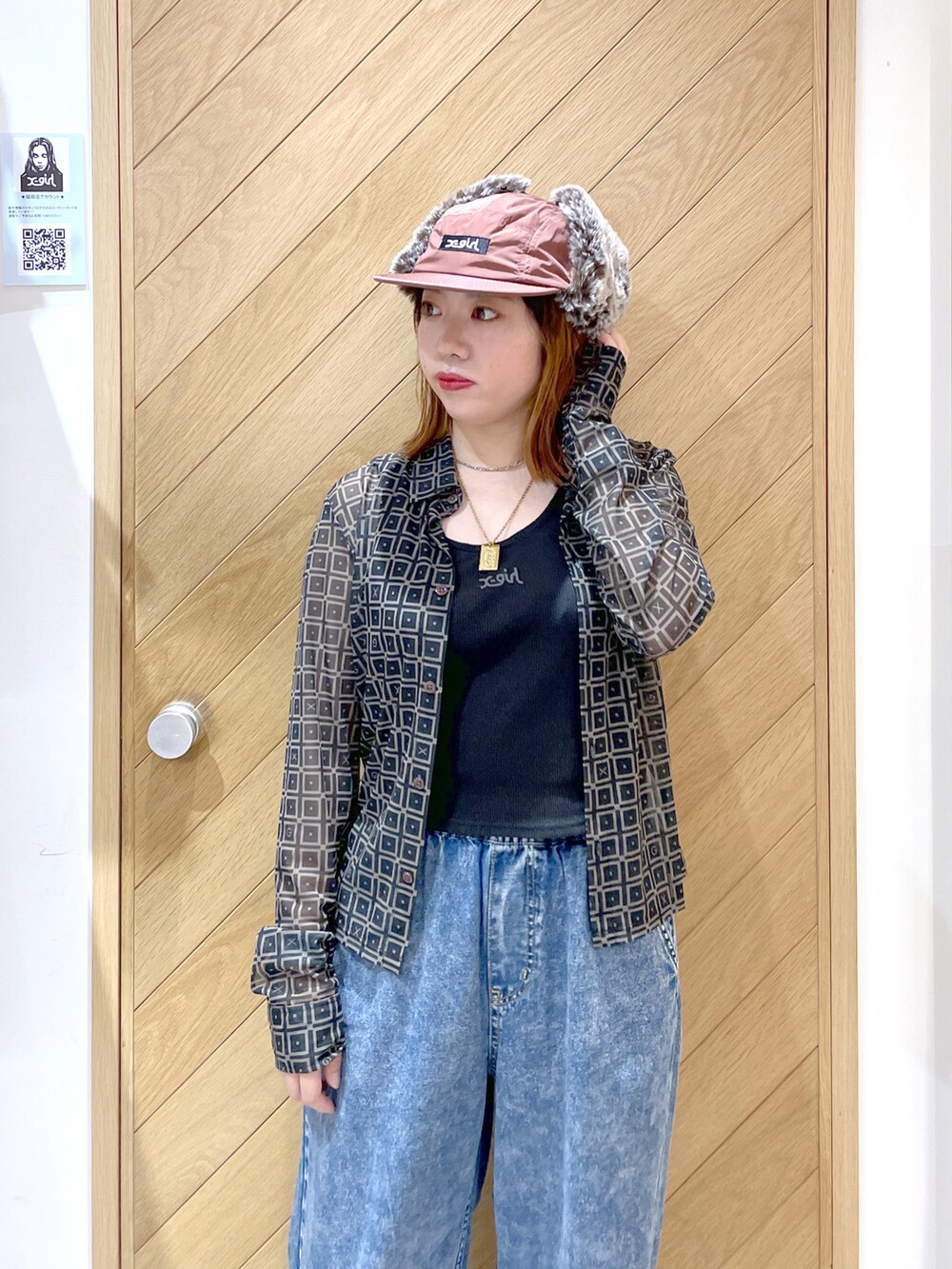 ブラック系のブーツ、ブルー系のデニムパンツ、ブラック系のタンクトップを着用したレディースの秋コーディネートの2枚目の写真