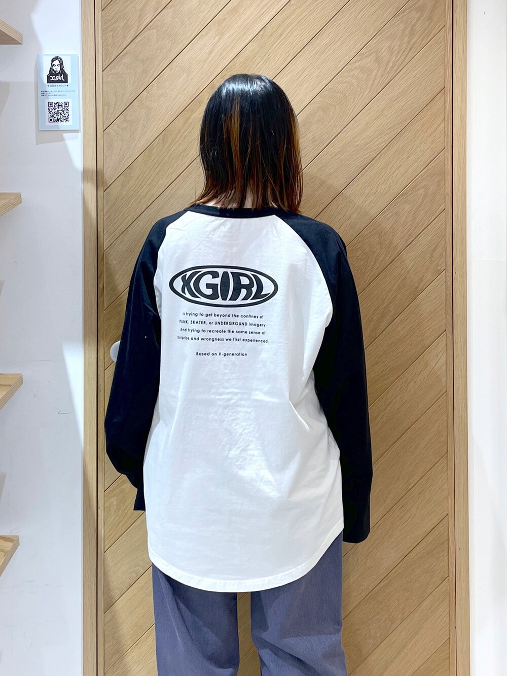 パープル系のデニムパンツ、ブラック系のブーツ、ホワイト系のTシャツ/カットソーを着用したレディースの冬コーディネートの4枚目の写真