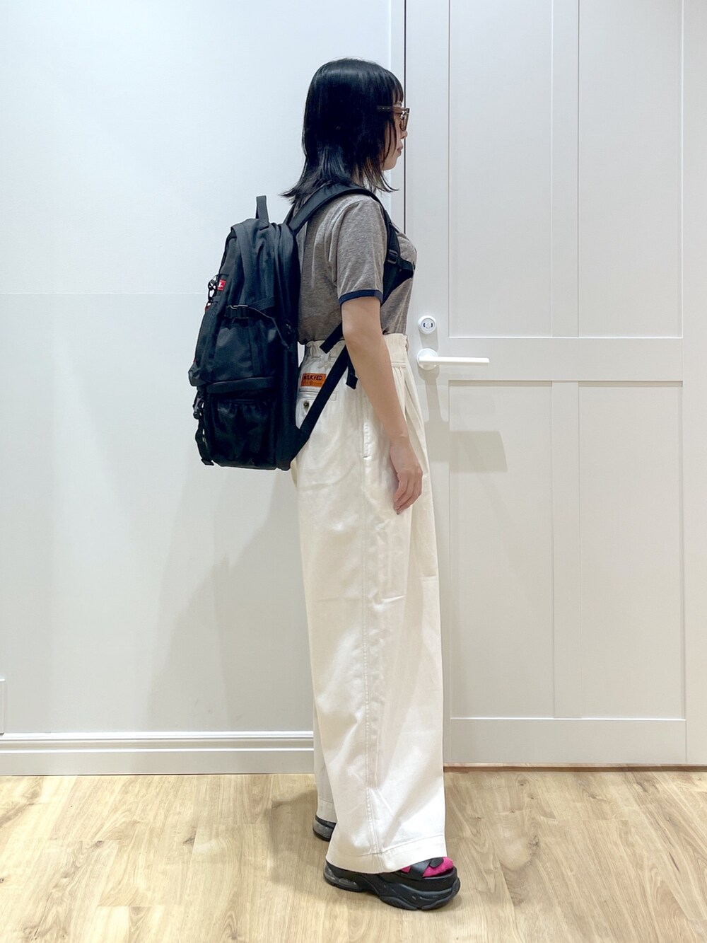 ホワイト系のその他パンツ、グレー系のTシャツ/カットソー、レッド系のバックパック/リュックを着用したレディースの夏コーディネートの3枚目の写真