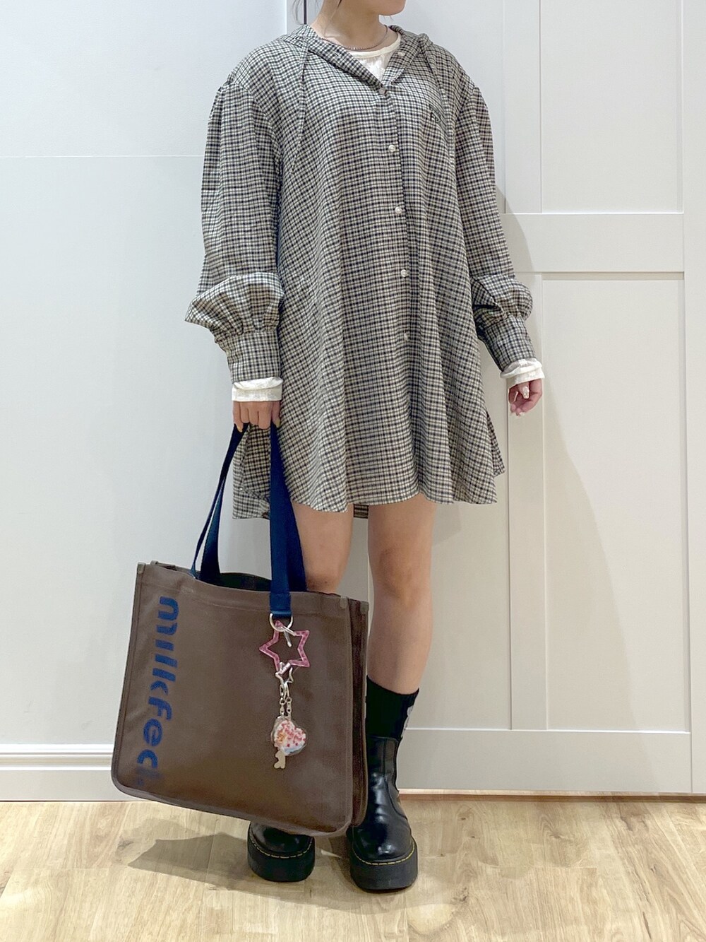 ブラック系のブーツ、ホワイト系のTシャツ/カットソー、ベージュ系のシャツ/ブラウスを着用したレディースの夏コーディネートの4枚目の写真