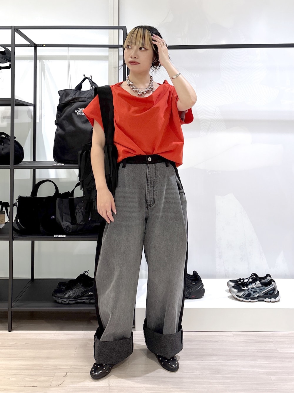 ブラック系のショルダーバッグ、ブラック系のその他シューズ、レッド系のTシャツ/カットソーを着用したレディースの春コーディネートの4枚目の写真