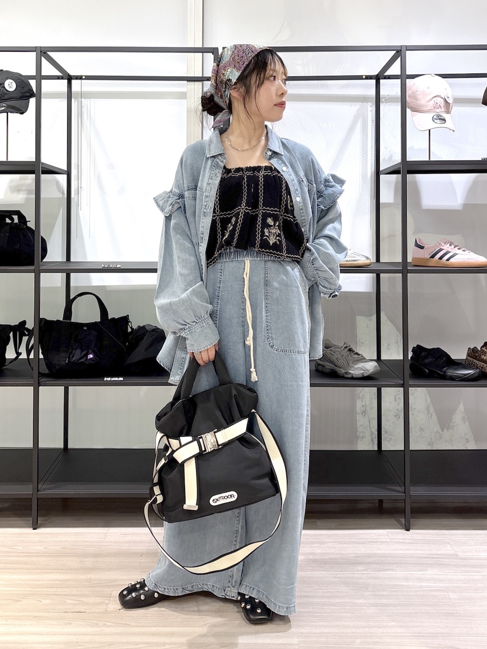 ブラック系のその他シューズ、ブラック系のトートバッグ、ブルー系のデニムパンツを着用したレディースの春コーディネートの2枚目の写真