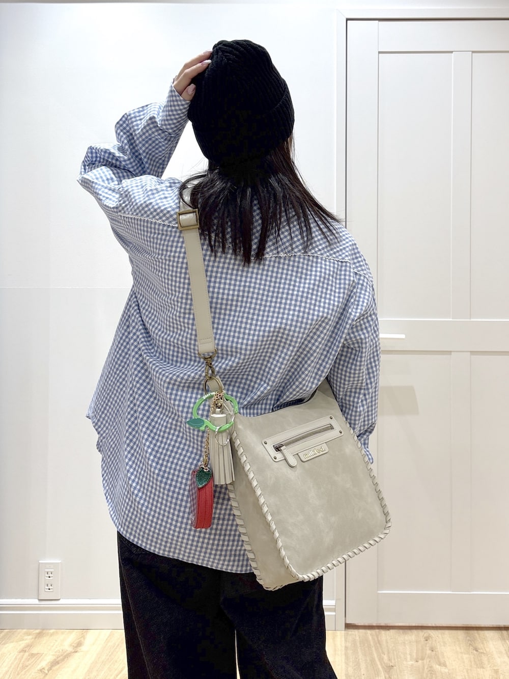 ブラック系のデニムパンツ、ホワイト系のTシャツ/カットソー、グレー系のショルダーバッグを着用したレディースの冬コーディネートの5枚目の写真