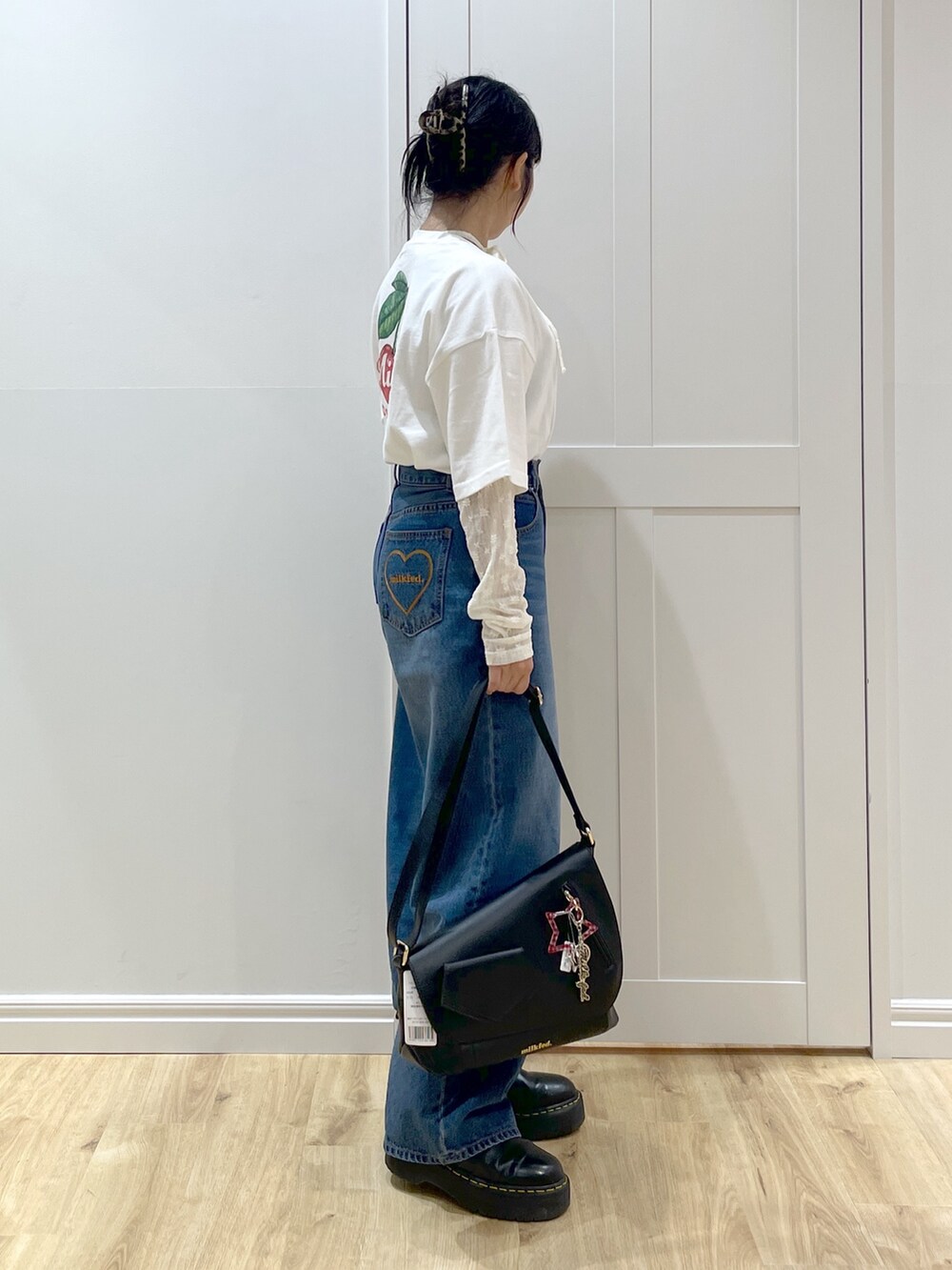 ブラック系のショルダーバッグ、ホワイト系のTシャツ/カットソー、ホワイト系のTシャツ/カットソーを着用したレディースの夏コーディネートの2枚目の写真