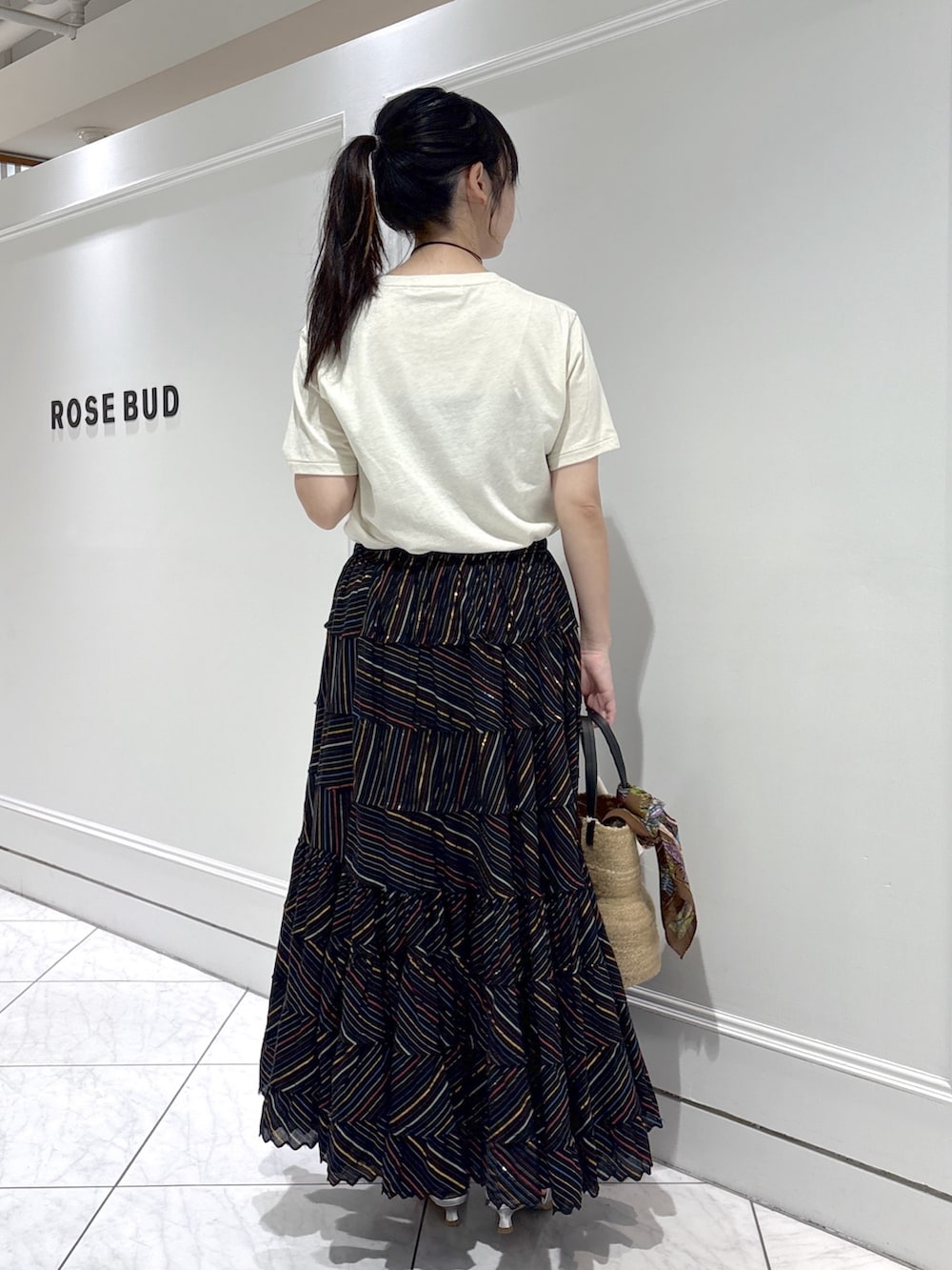 ベージュ系のトートバッグ、シルバー系のサンダル、ホワイト系のTシャツ/カットソーを着用したレディースの春コーディネートの3枚目の写真
