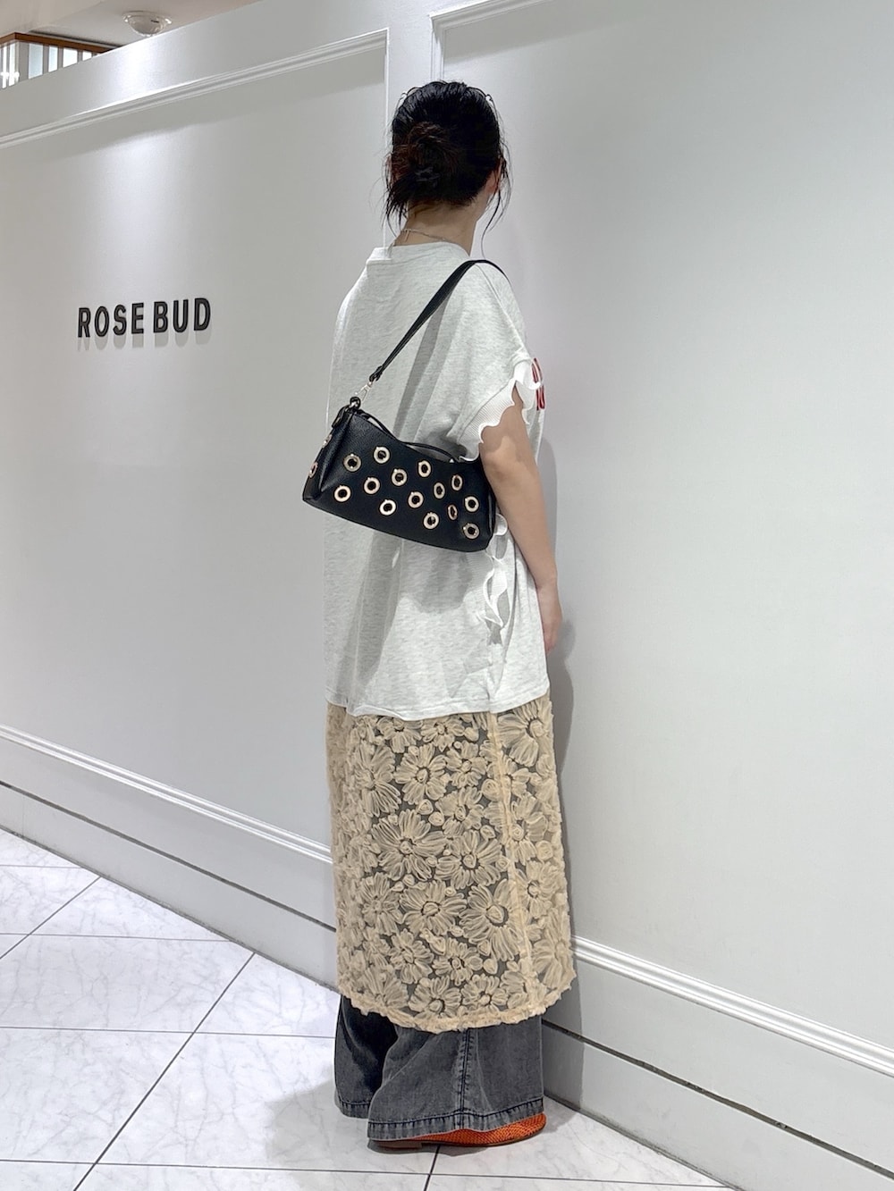 ベージュ系のワンピース、ブラック系のパンプス、ブラック系のショルダーバッグを着用したレディースの夏コーディネートの2枚目の写真