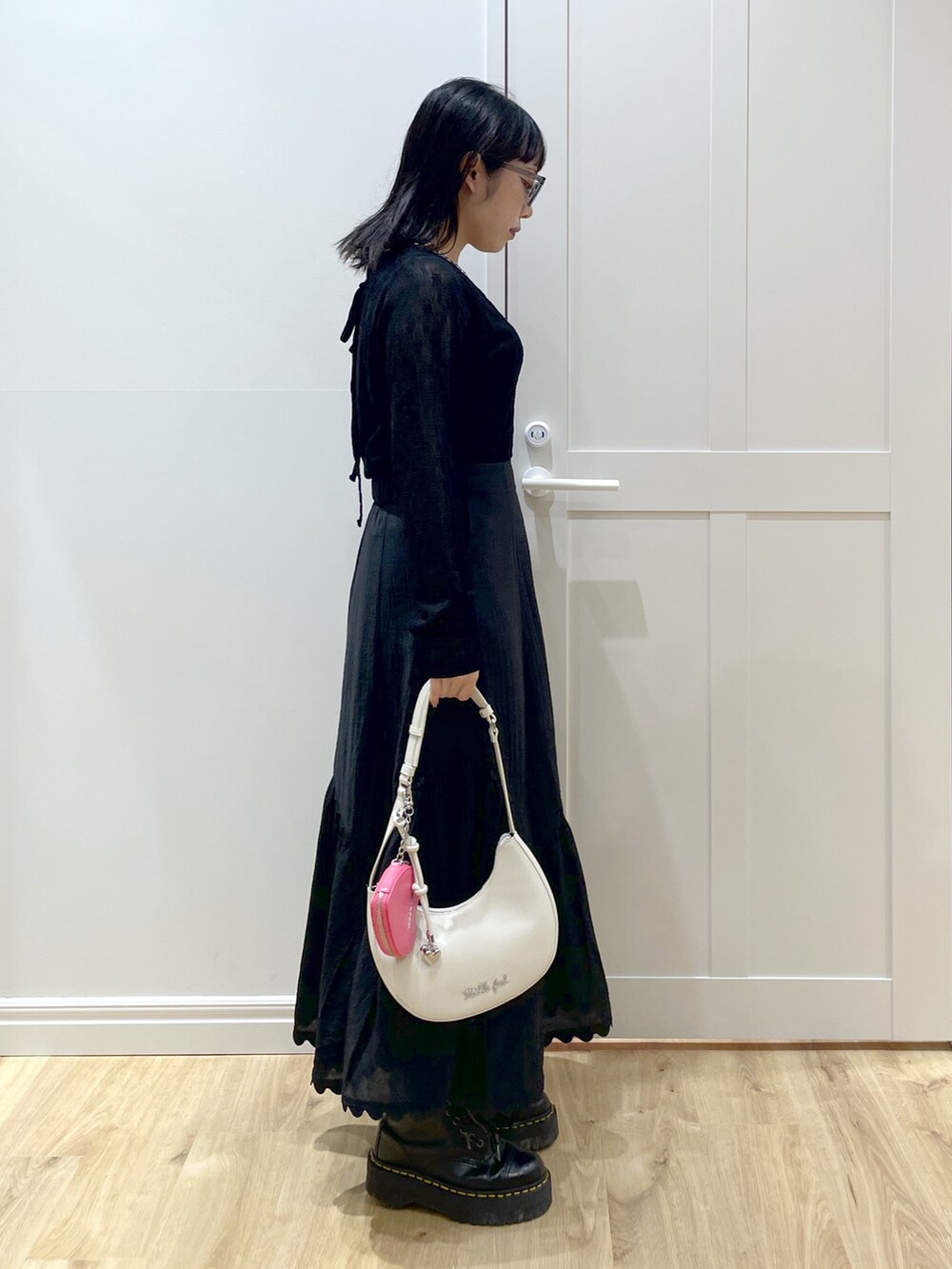 ブラック系のブーツ、ブラック系のスカート、ブラック系のタンクトップを着用したレディースの夏コーディネートの2枚目の写真