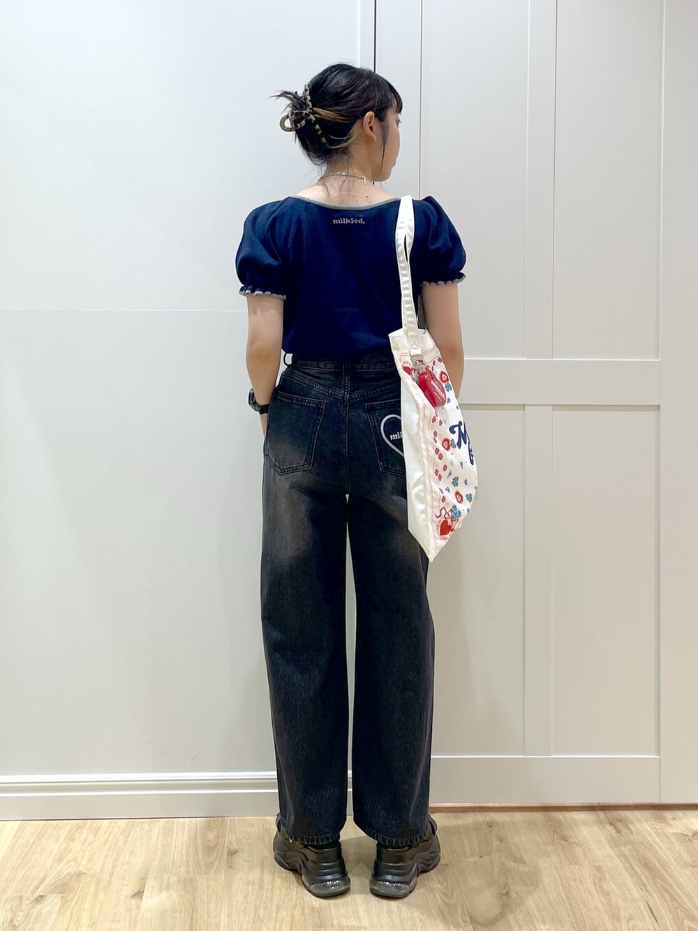 ブルー系のニット/セーター、ブラック系のデニムパンツ、ブラック系のサンダルを着用したレディースの夏コーディネートの3枚目の写真