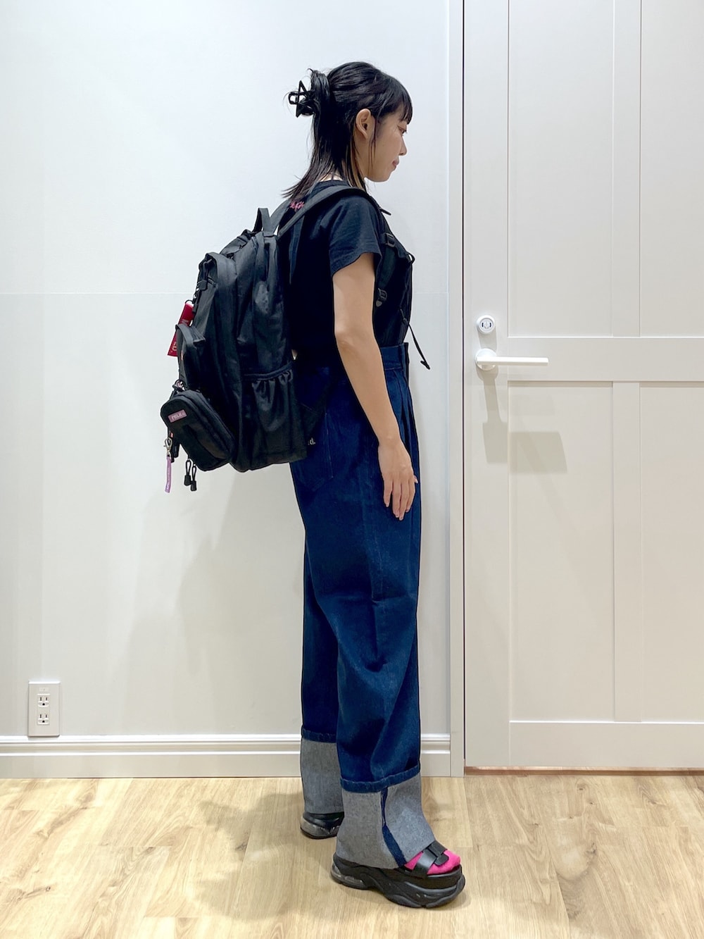 ブラック系のTシャツ/カットソー、ブルー系のデニムパンツ、ブラック系のサンダルを着用したレディースの夏コーディネートの3枚目の写真