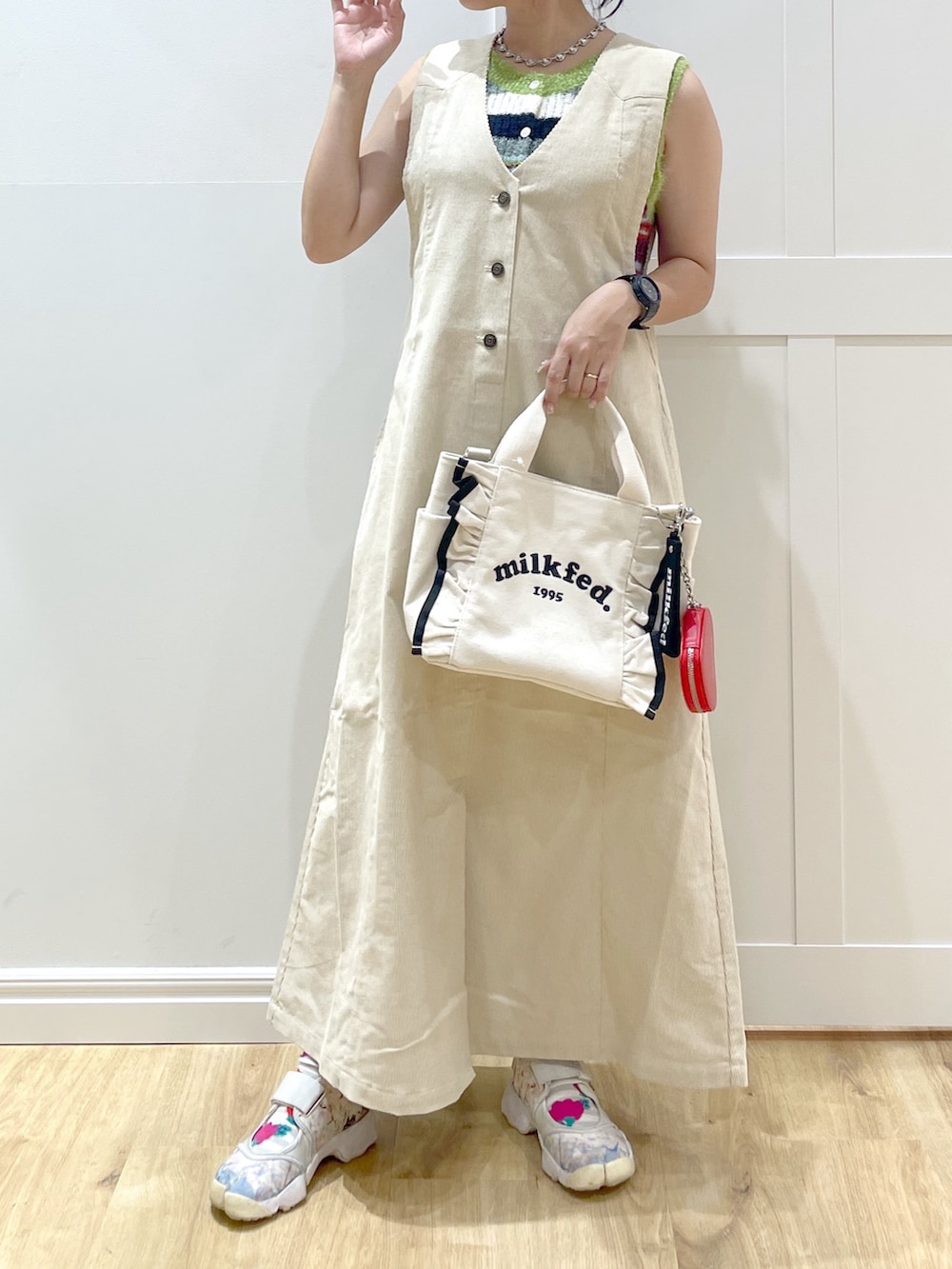 ベージュ系のワンピース、パープル系のニット/セーター、ホワイト系のショルダーバッグを着用したレディースの秋コーディネートの4枚目の写真