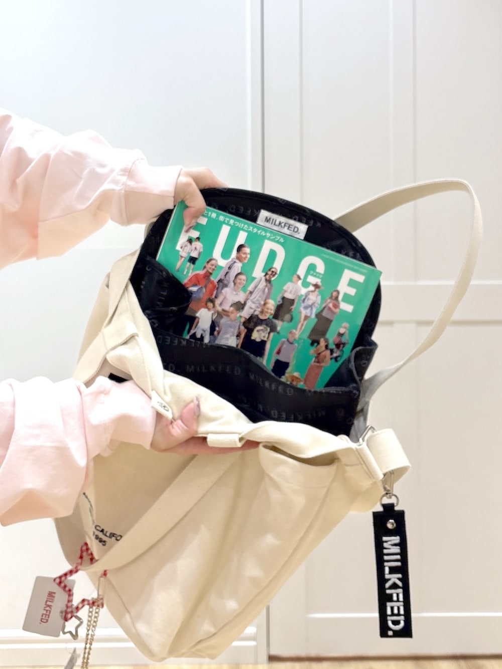 ホワイト系のTシャツ/カットソー、ブルー系のデニムパンツ、ホワイト系のトートバッグを着用したレディースの冬コーディネートの6枚目の写真