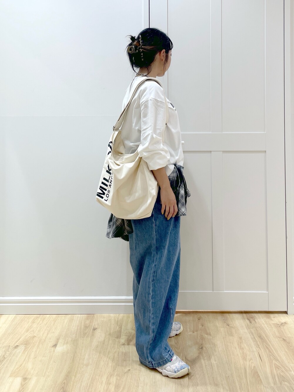 ホワイト系のTシャツ/カットソー、ブラック系のシャツ/ブラウス、ブルー系のデニムパンツを着用したレディースの秋コーディネートの3枚目の写真