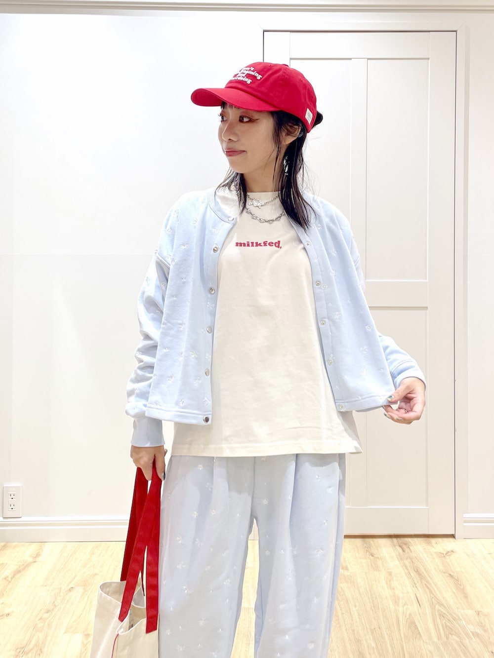 ホワイト系のトートバッグ、ブルー系のスウェット、ホワイト系のTシャツ/カットソーを着用したレディースの秋コーディネートの5枚目の写真