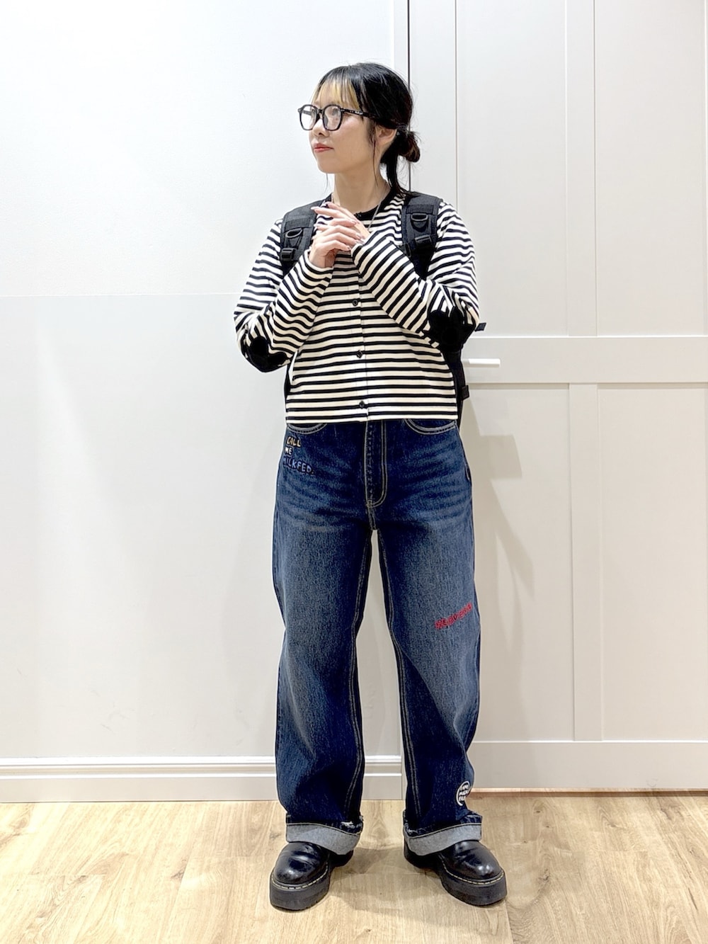 ブルー系のデニムパンツ、ブラック系のブーツ、ブラック系のカーディガン/ボレロを着用したレディースの春コーディネートの3枚目の写真