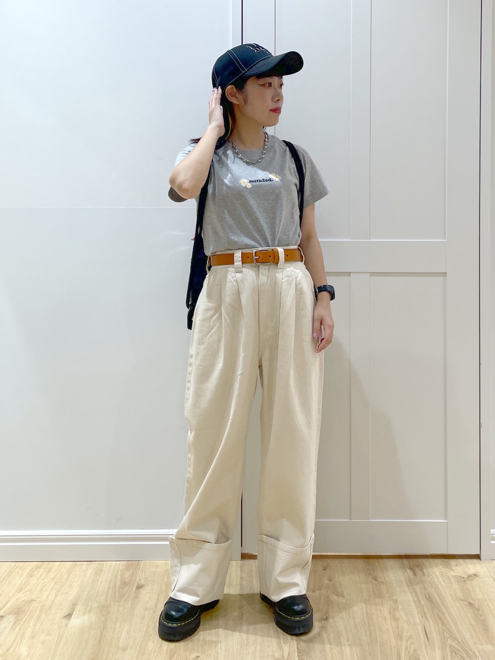 ホワイト系のデニムパンツ、ブラック系のブーツ、グレー系のTシャツ/カットソーを着用したレディースの夏コーディネートの4枚目の写真