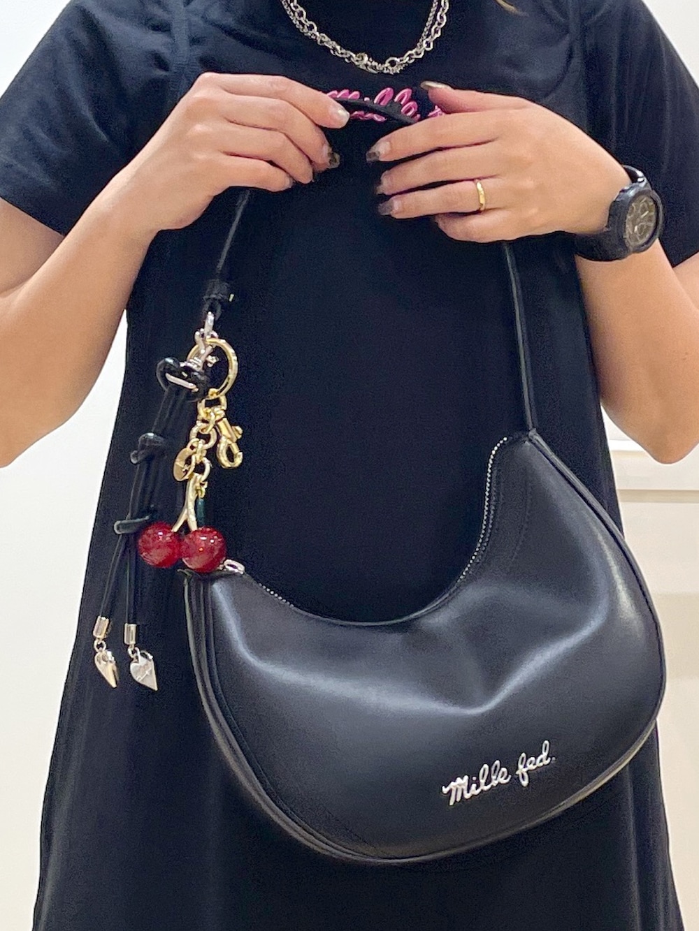 ブラック系のワンピース、ブラック系のTシャツ/カットソー、ブラック系のハンドバッグを着用したレディースの春コーディネートの3枚目の写真