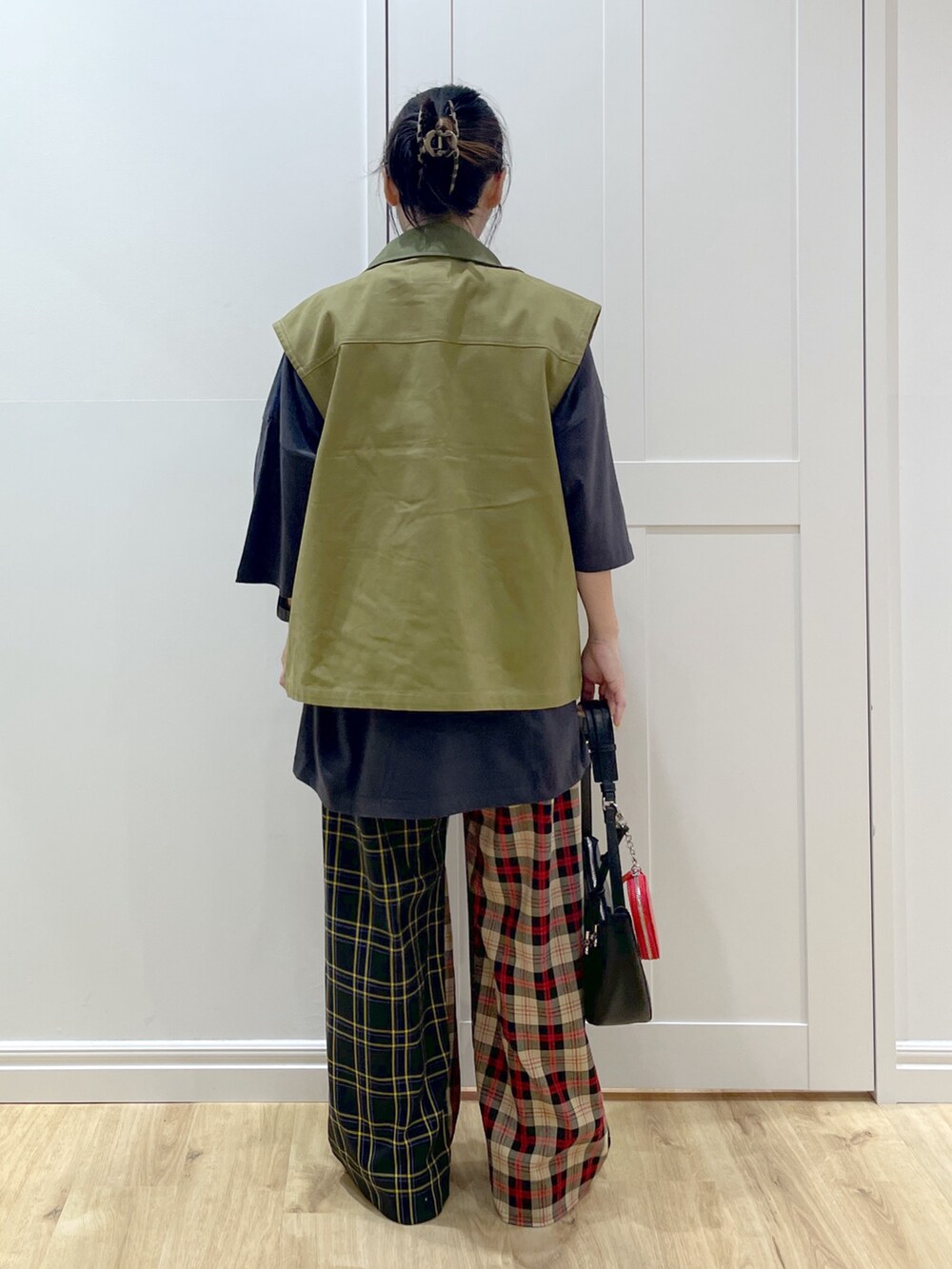 ブラック系のその他パンツ、グリーン系のベスト、グレー系のTシャツ/カットソーを着用したレディースの秋コーディネートの2枚目の写真