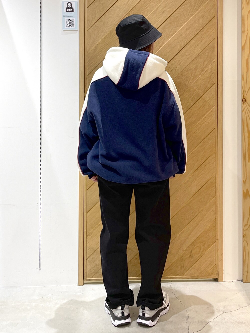 ブルー系のパーカー、ホワイト系のスニーカー、ブラック系のデニムパンツを着用したレディースの冬コーディネートの2枚目の写真