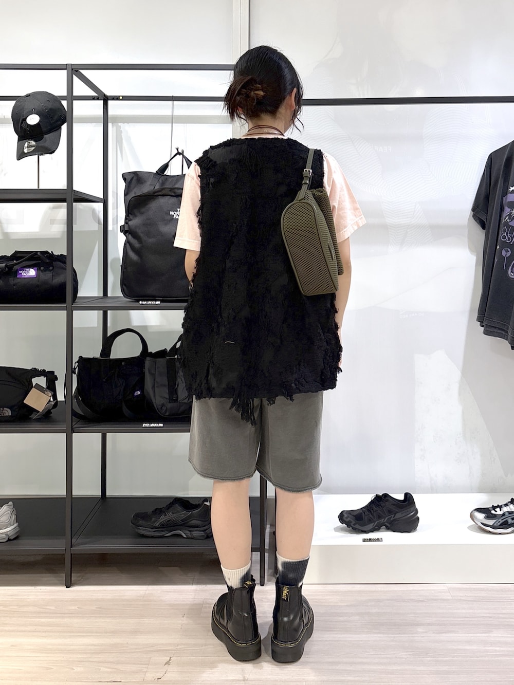 グリーン系のショルダーバッグ、ブラック系のブーツ、ピンク系のTシャツ/カットソーを着用したレディースの春コーディネートの3枚目の写真