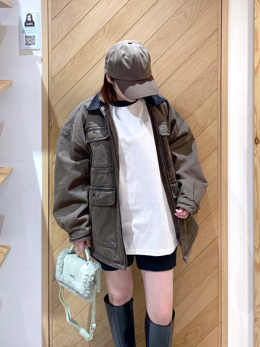 ブラック系のブーツ、グリーン系のショルダーバッグ、ブラウン系のデニムジャケットを着用したレディースの冬コーディネートの3枚目の写真