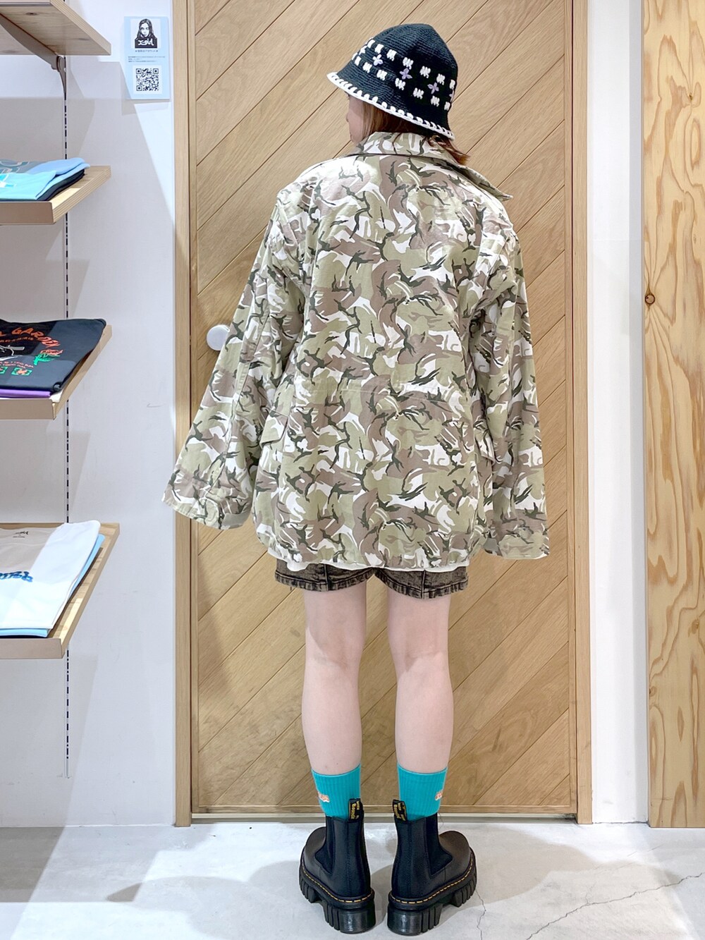 ホワイト系のタンクトップ、ベージュ系のミリタリージャケット、ブラウン系のデニムパンツを着用したレディースの秋コーディネートの3枚目の写真