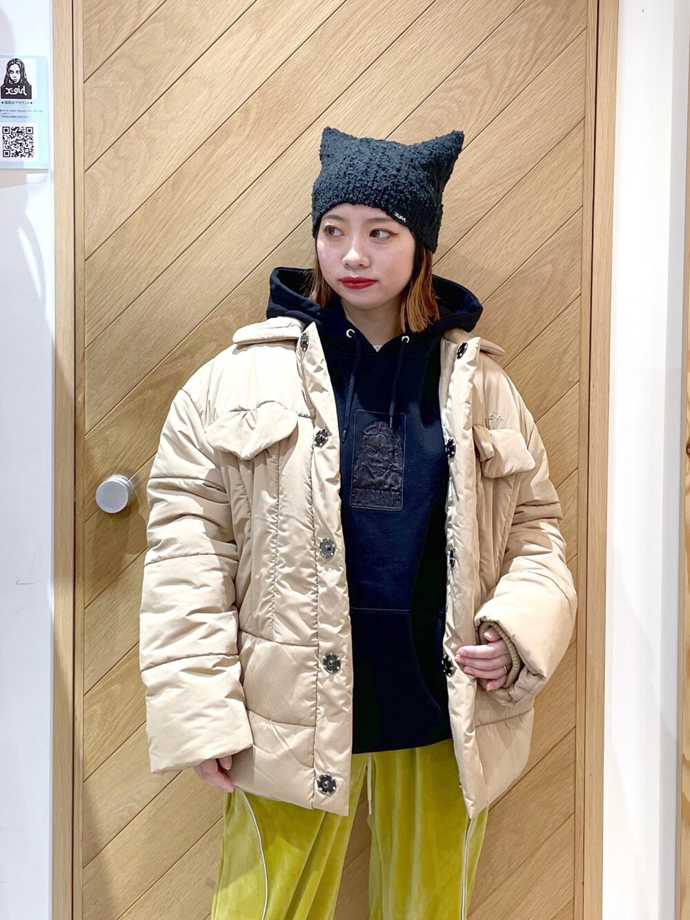ブラック系のパーカー、ベージュ系のその他アウター、イエロー系のその他パンツを着用したレディースの秋コーディネートの2枚目の写真