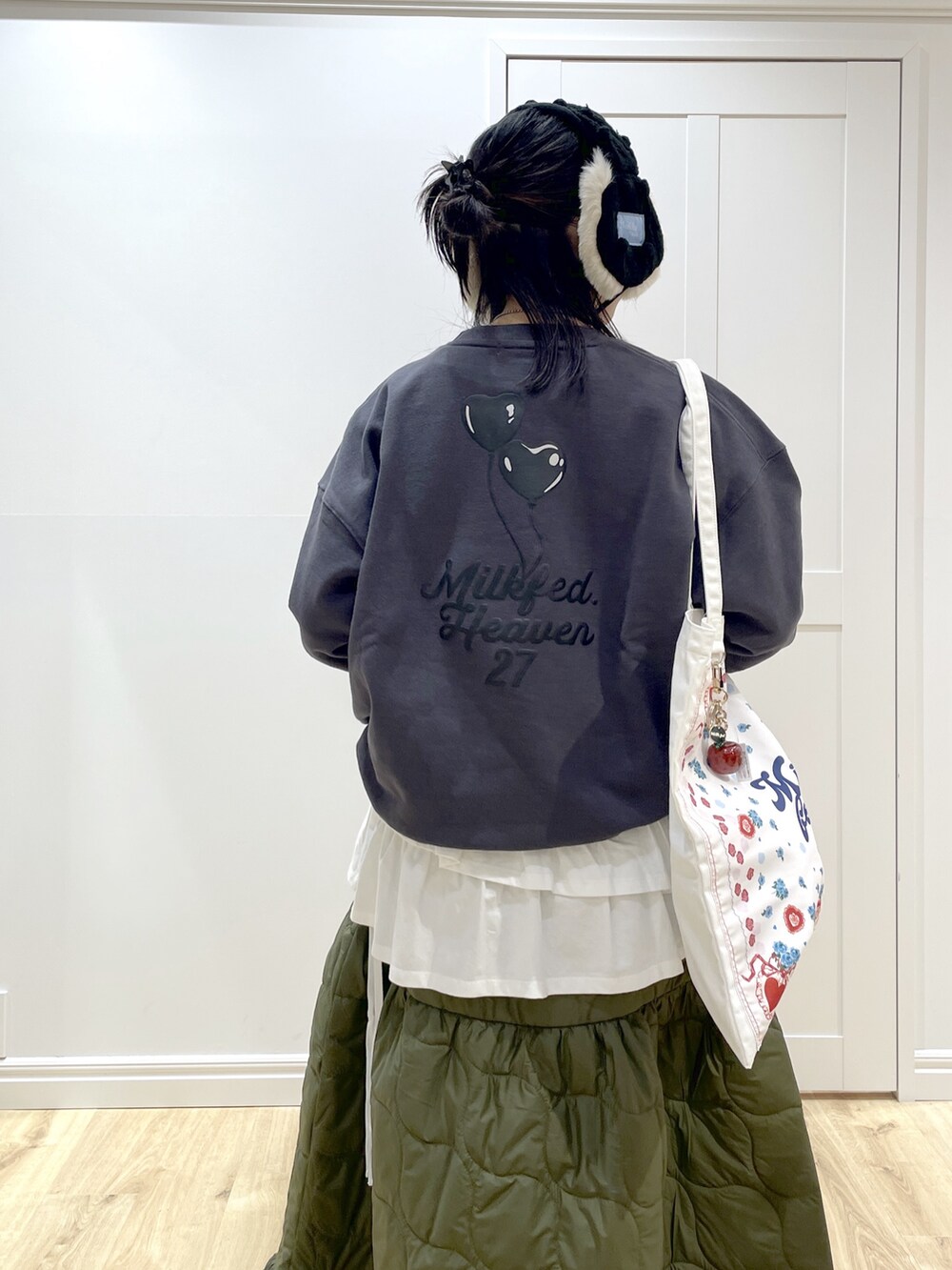 グリーン系のスカート、ホワイト系のTシャツ/カットソー、ホワイト系のトートバッグを着用したレディースの秋コーディネートの5枚目の写真