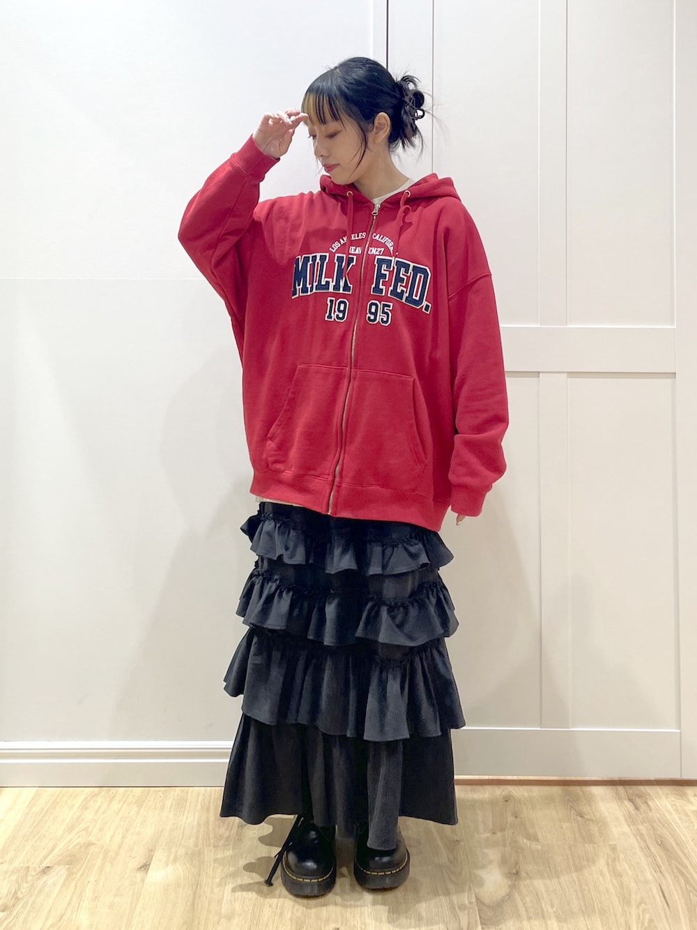 ブラック系のブーツ、ブラック系のショルダーバッグ、ブラック系のスカートを着用したレディースの冬コーディネートの2枚目の写真