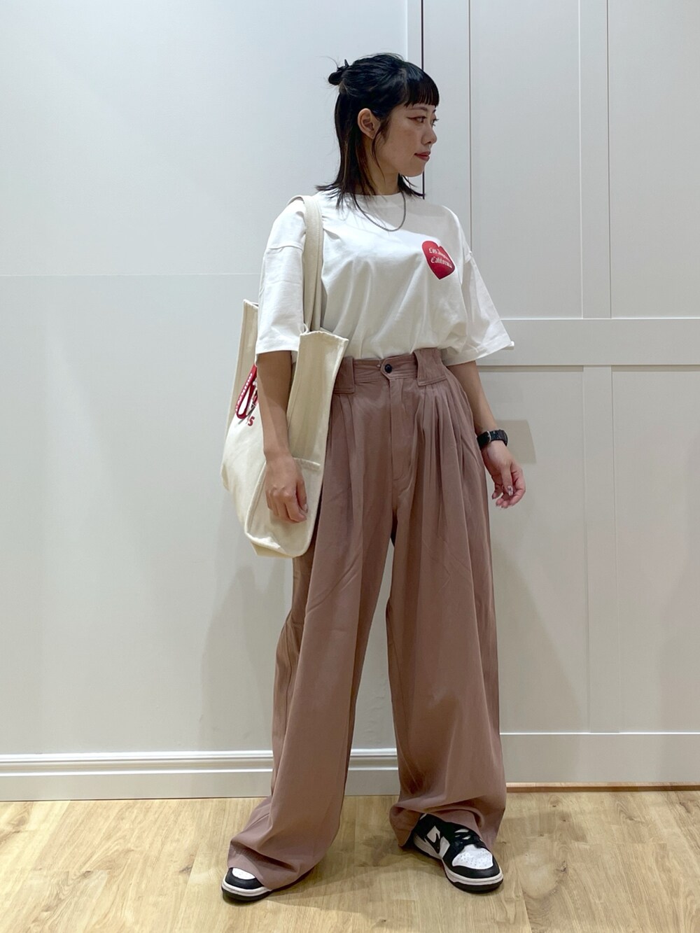 ホワイト系のTシャツ/カットソー、ホワイト系のスニーカー、ホワイト系のトートバッグを着用したレディースの夏コーディネートの2枚目の写真