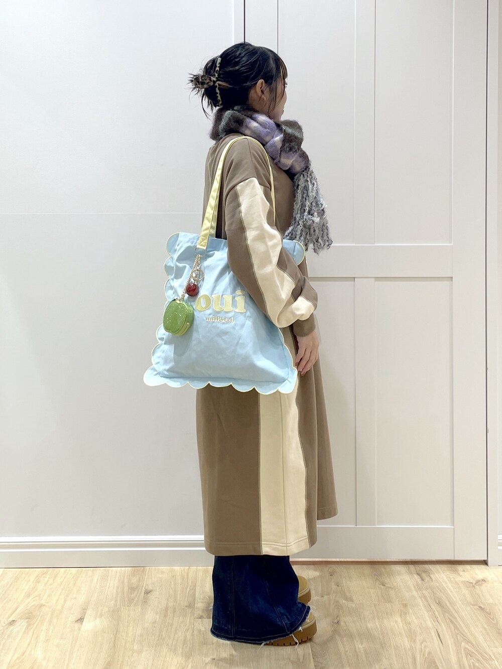 ベージュ系のブーツ、ブルー系のトートバッグ、ブラウン系のワンピースを着用したレディースの秋コーディネートの3枚目の写真