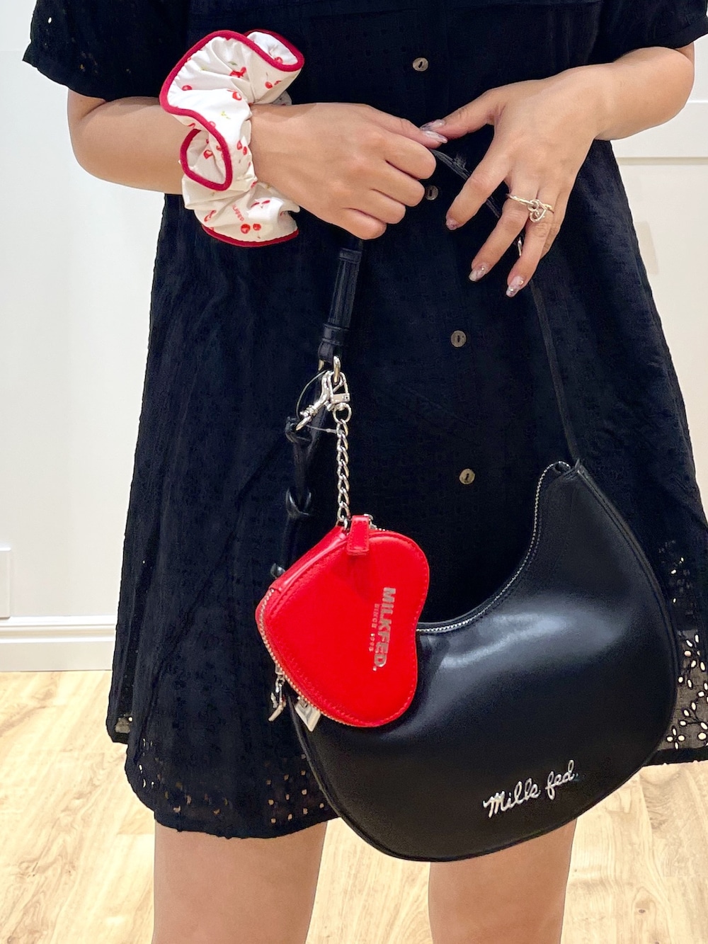 ブラック系のサンダル、ブラック系のワンピース、ブラック系のハンドバッグを着用したレディースの夏コーディネートの4枚目の写真