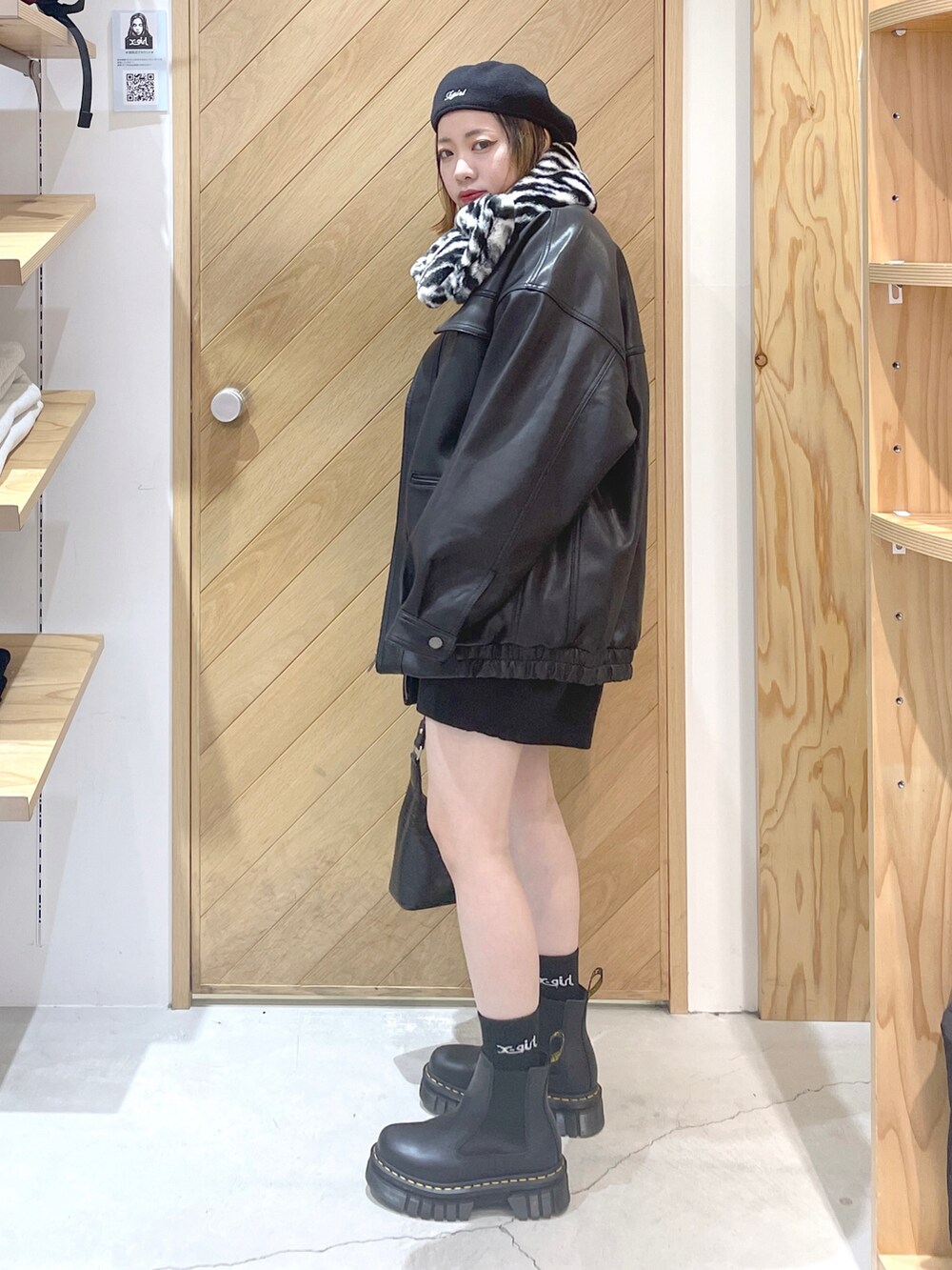 ブラック系のニット/セーター、ブラック系のライダースジャケット、ブラック系のハンドバッグを着用したレディースの秋コーディネートの3枚目の写真