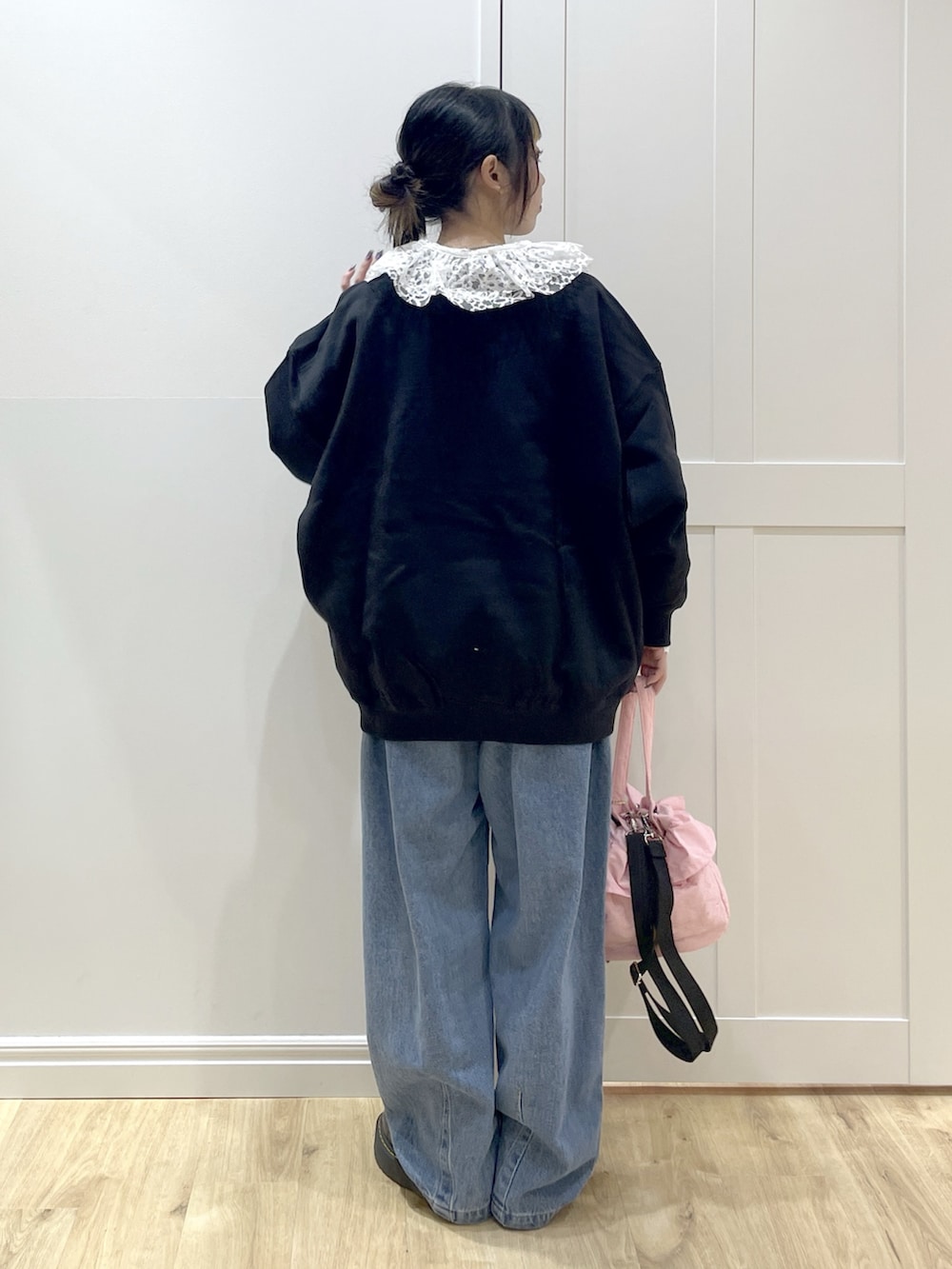 ブラック系のスウェット、ブルー系のデニムパンツ、ホワイト系のシャツ/ブラウスを着用したレディースの冬コーディネートの3枚目の写真