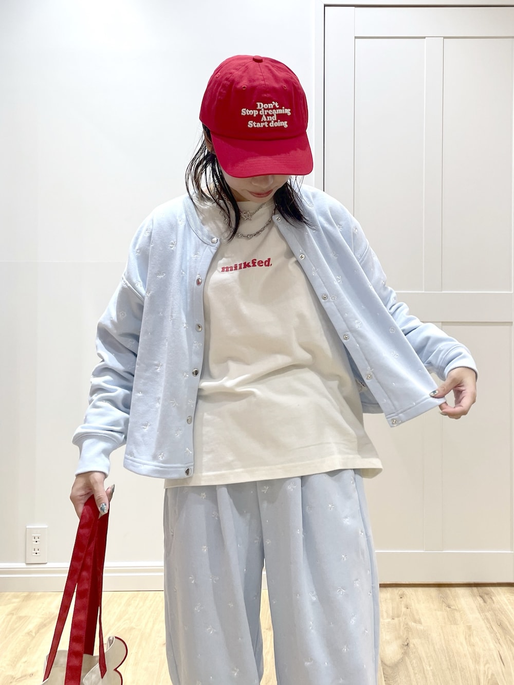 ホワイト系のトートバッグ、ブルー系のスウェット、ホワイト系のTシャツ/カットソーを着用したレディースの秋コーディネートの6枚目の写真