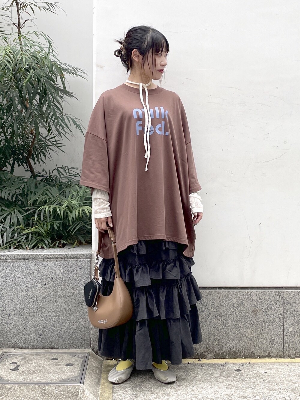 ブラック系のスカート、ホワイト系のTシャツ/カットソー、ブラウン系のTシャツ/カットソーを着用したレディースの秋コーディネートの4枚目の写真