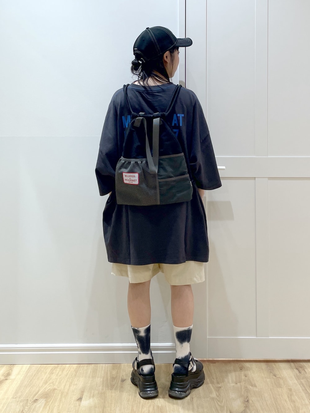 ブラック系のサンダル、グレー系のTシャツ/カットソー、ブラック系のバックパック/リュックを着用したレディースの夏コーディネートの2枚目の写真