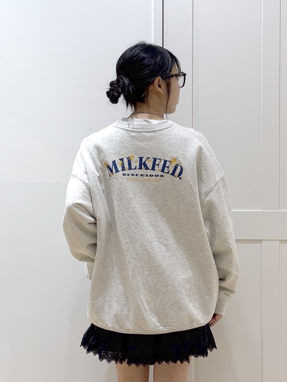 ブラック系のスカート、ベージュ系のスウェット、グリーン系のバックパック/リュックを着用したレディースの春コーディネートの6枚目の写真