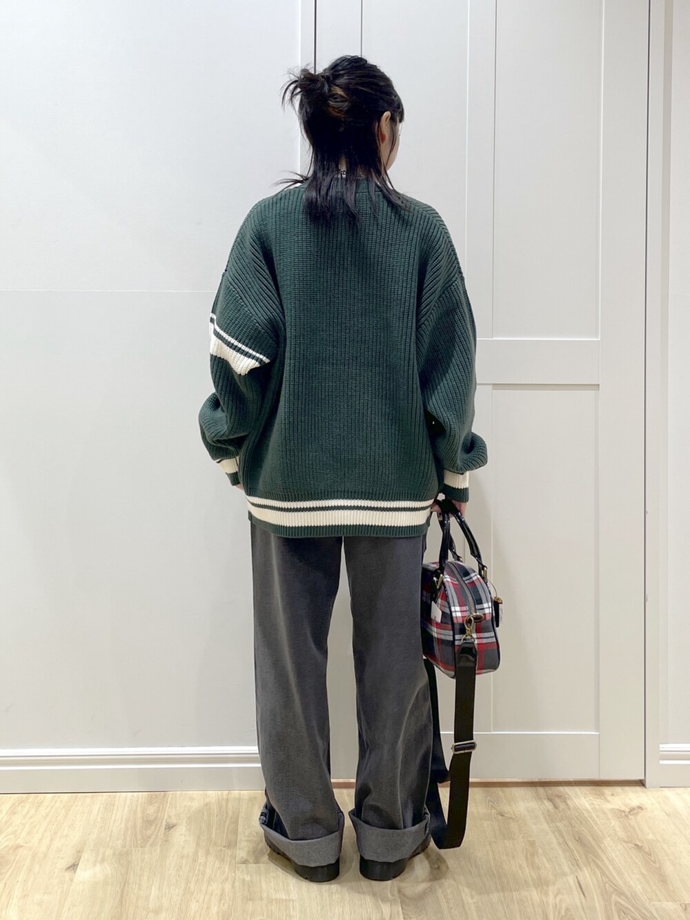 グリーン系のカーディガン/ボレロ、ホワイト系のTシャツ/カットソー、ブラック系のデニムパンツを着用したレディースの秋コーディネートの3枚目の写真