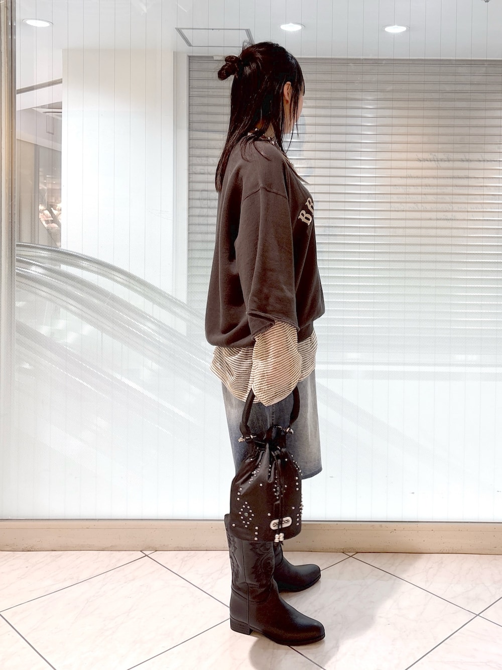 ブラック系のブーツ、ブラック系のショルダーバッグ、ブルー系のその他パンツを着用したレディースの春コーディネートの3枚目の写真