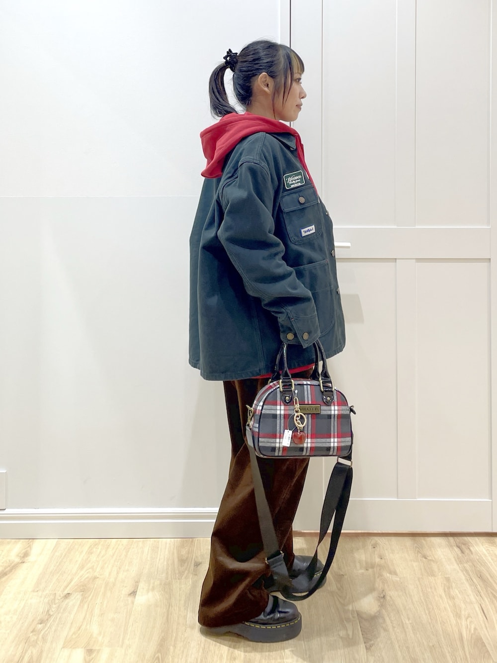 ブラック系のTシャツ/カットソー、レッド系のパーカー、ブラック系のブルゾンを着用したレディースの秋コーディネートの2枚目の写真