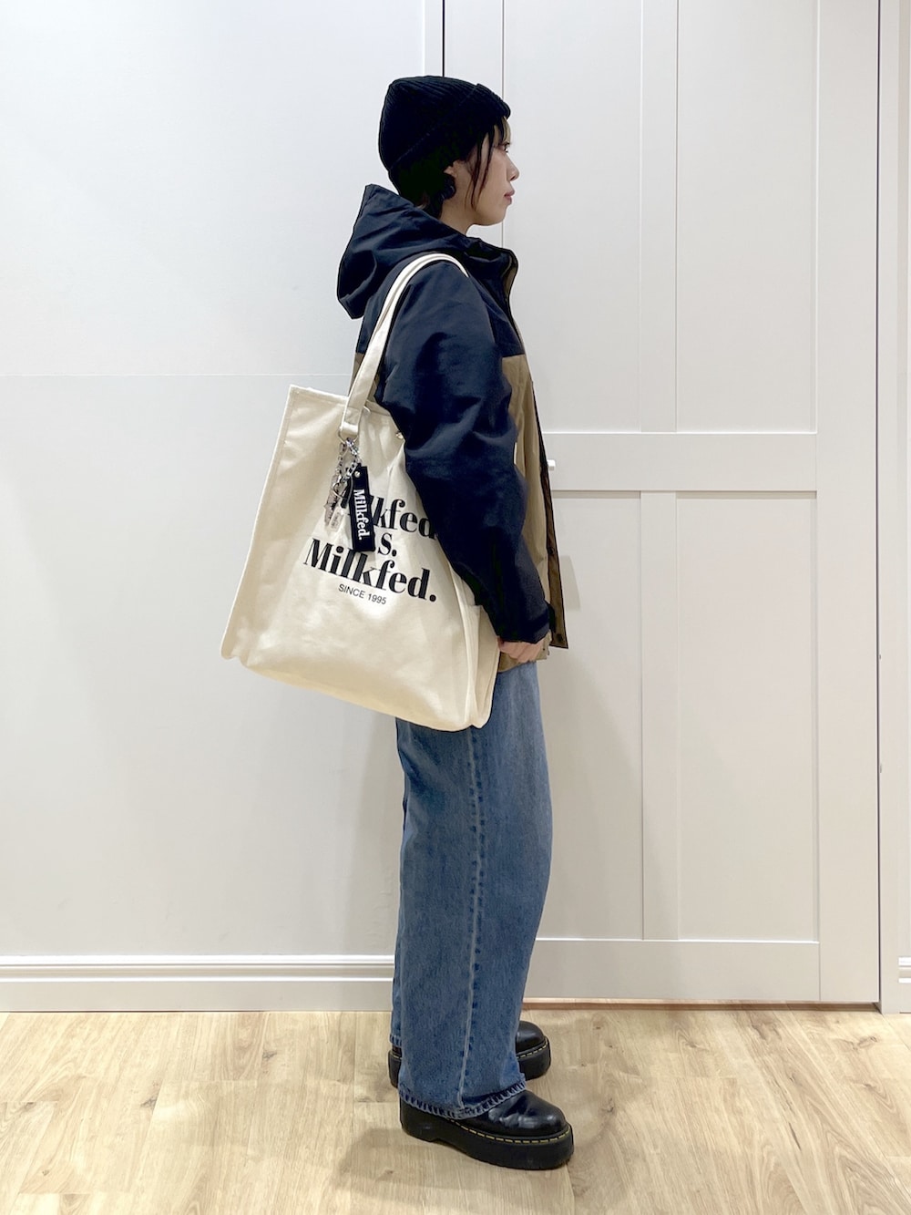 ブルー系のデニムパンツ、イエロー系のシャツ/ブラウス、ベージュ系のマウンテンパーカーを着用したレディースの冬コーディネートの3枚目の写真