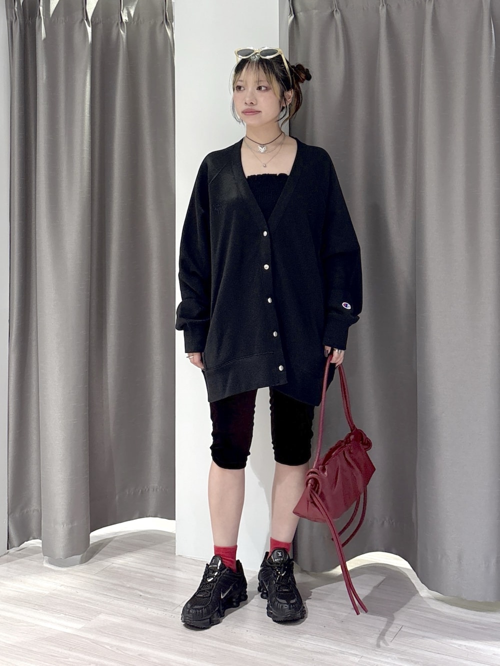 ブラック系のスウェット、ブラウン系のその他パンツ、レッド系のハンドバッグを着用したレディースの秋コーディネートの5枚目の写真