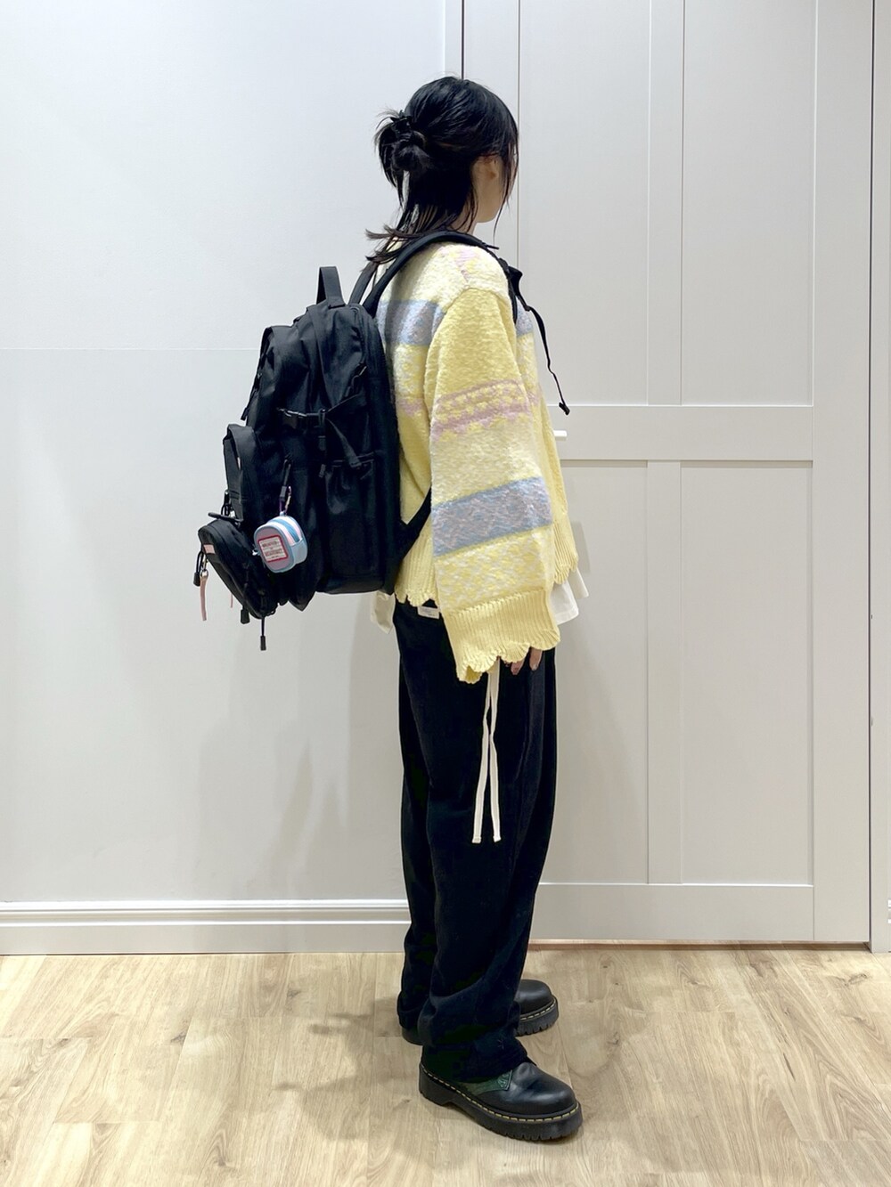 ピンク系のTシャツ/カットソー、イエロー系のニット/セーター、ブラック系のスウェットパンツを着用したレディースの秋コーディネートの3枚目の写真