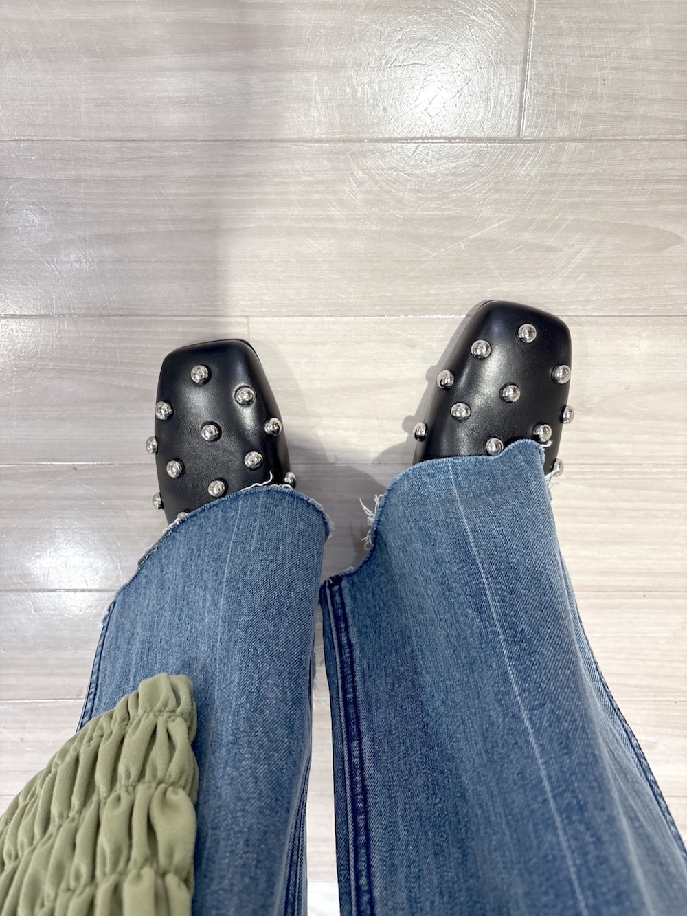 グリーン系のトートバッグ、ブラック系のサンダル、ブルー系のデニムパンツを着用したレディースの春コーディネートの5枚目の写真