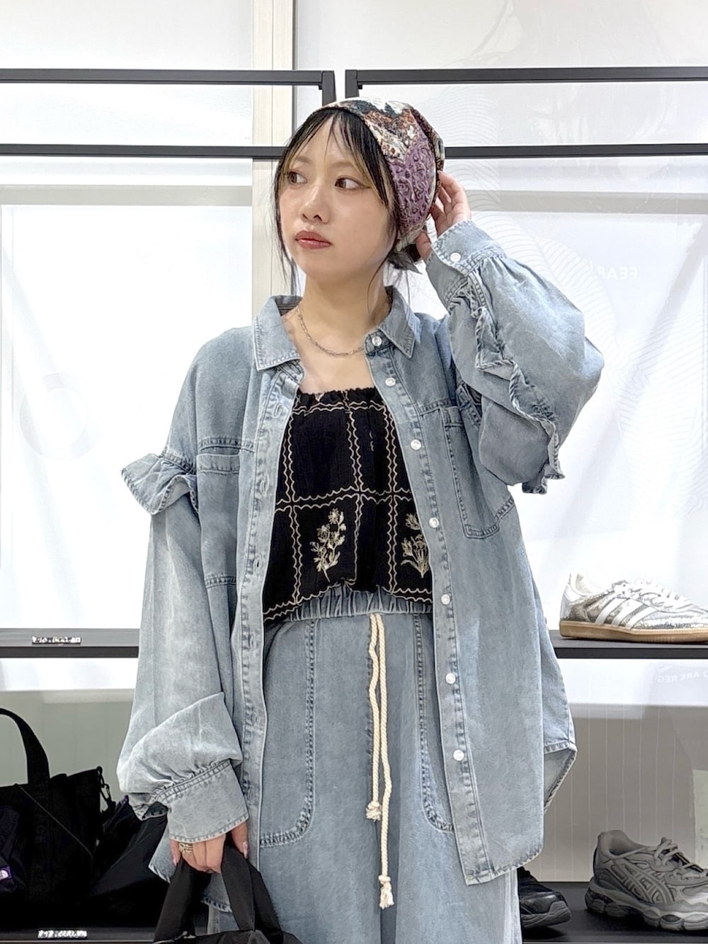 ブラック系のその他シューズ、ブラック系のトートバッグ、ブルー系のデニムパンツを着用したレディースの春コーディネートの5枚目の写真