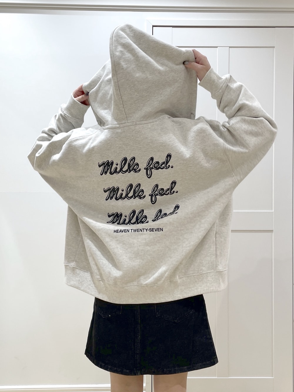 ホワイト系のTシャツ/カットソー、ベージュ系のパーカー、ブラック系のデニムスカートを着用したレディースの冬コーディネートの5枚目の写真