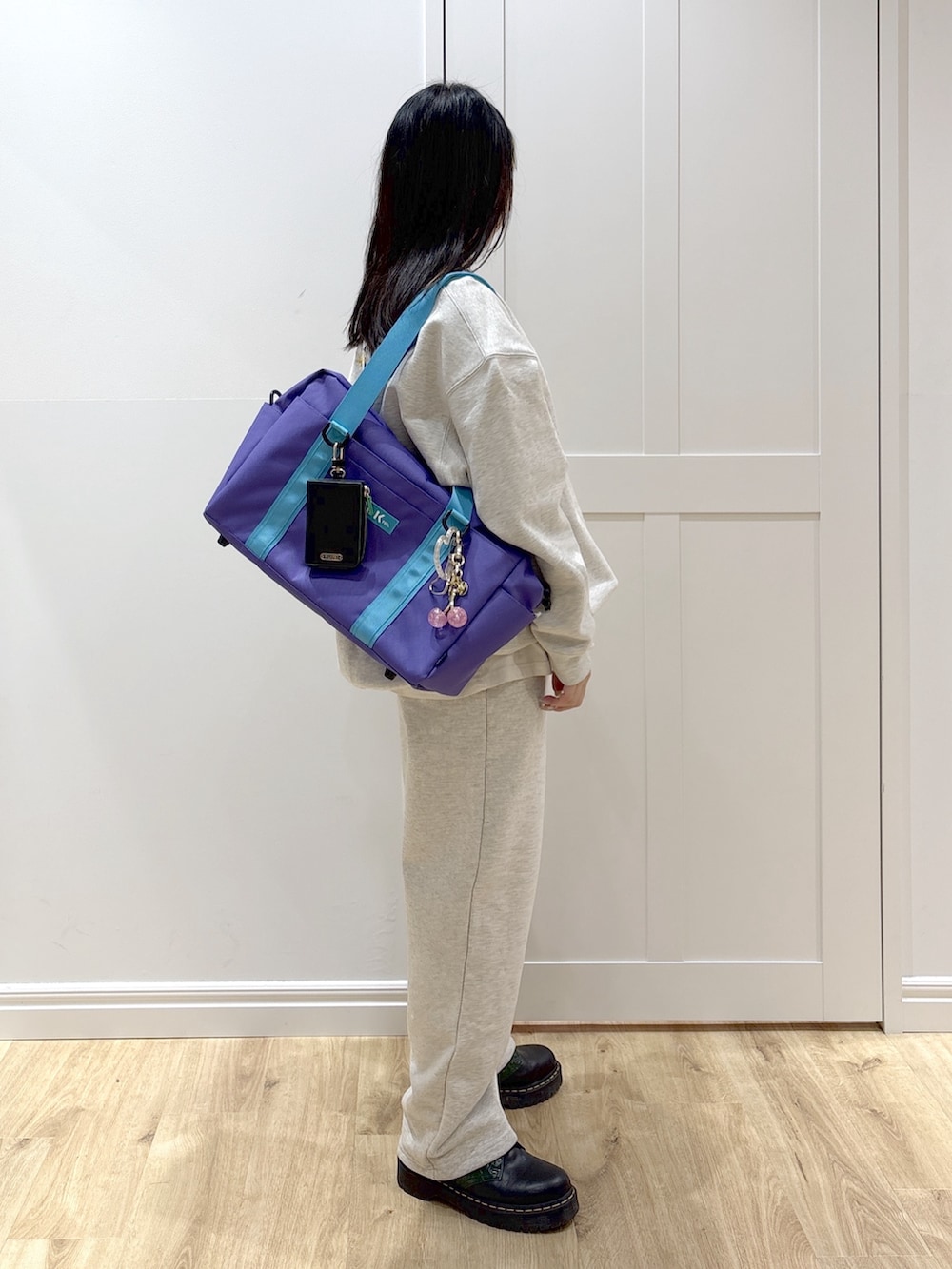 ベージュ系のスウェット、ベージュ系のスウェットパンツ、パープル系のショルダーバッグを着用したレディースの冬コーディネートの3枚目の写真